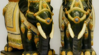 Coppia di sculture in ceramica smaltata raffiguranti due elefnti